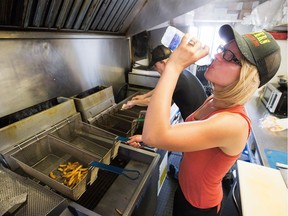 Jade Hawkins stays hydrated while she battles 50 C degrees at her fryers thanks to the high heat in the region today. She says she loses 20-30 lbs. in the summer from sweating so much. Despite the heat, her customers kept coming today, maybe because it's National French Fry Day.
