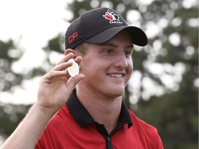 Jared du Toit, of Canada, holds up the Gary Cowan Award for low amateur after finishing T9 at the Canadian open golf tournament at Glen Abbey in Oakville, Ontario, on Sunday, July 24, 2016.