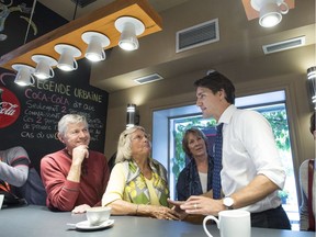 Liberal leader Justin Trudeau chats with supporters during a campaign stop at a coffee shop Tuesday, October 6, 2015 in Granby, Que.