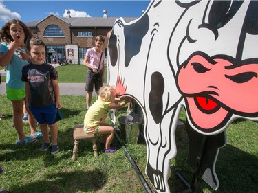 Kids learn how to milk a cow as the National Ice Cream Day is celebrated as the National Ice Cream Day is celebrated at the Ice Cream Festival taking place Sunday at the Canada Agriculture and Food Museum.