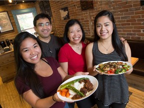 Lito and Liza Sare, centre, with their daughters Jessica, 23, left and Jiselle Sare, 20, are proud owners of Tamis Café at 103 Fourth Ave., just east of Bank Street. They are shown with two Filipino dishes, Braised Beef Mechado and Grilled Chicken Adobo.