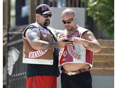 Members of the Hells Angels look at a phone as they stand outside the Hells Angels Nomads compound before the group's Canada Run event on Friday, July 22, 2016, in Carlsbad Springs, Ont., near Ottawa.