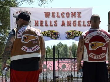 Members of the Hells Angels look on as their banner is raised outside the Hells Angels Nomads compound before the group's Canada Run event in Carlsbad Springs, Ont., near Ottawa, on Friday, July 22, 2016.