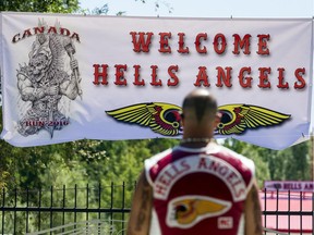 Members of the Hells Angels Nomads MC hang a welcome banner atop the gates to the clubhouse grounds in Carlsbad Springs Friday, July 22, 2016.