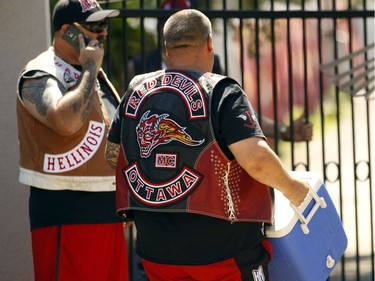Members of the Red Devils Motorcycle Club carry coolers into the Hells Angels Nomads clubhouse ground in Carlsbad Springs Friday, July 22, 2016. Hundreds of bikers from across the country are descending on the sleepy hamlet for the start of their Canada Run, an annual convention of sorts.
