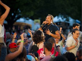 Michael Franti joins the crowd during his Ottawa Jazz Festival show at Confederation Park on Saturday, July 2, 2016.