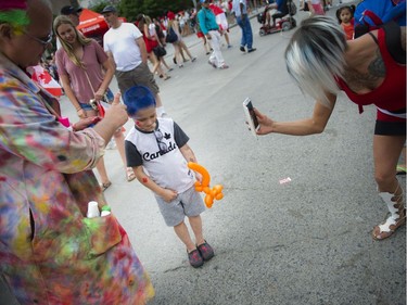 Mike Karpishka paints six-year-old Zahne Wurzl's hair blue on Canada Day, Friday, July 1, 2016.