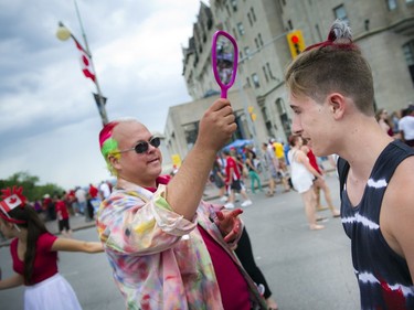 Mike Karpishka shows 14-year-old Alexy Coelho his fancy colourful Canada Day hair.