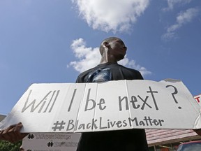 Niamke Ledbetter, of Oak Cliff, Texas, holds a sign at a Black Lives Matter protest on Park Lane in Dallas, Sunday, July 10, 2016.