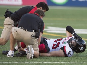 Medical personnel attend to Ottawa Redblacks linebacker Olivier Goulet-Veilleux as he lies injured during second quarter CFL football action against the Montreal Alouettes on Thursday, June 30, 2016.