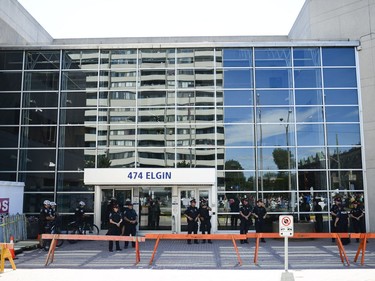 Ottawa police stands behind the barricade set up at Ottawa police headquarters on Elgin Street during the March for Justice - In Memory of Abdirahman Abdi. Saturday, July 30, 2016.