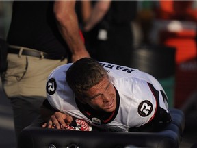 Ottawa Redblacks quarterback Trevor Harris winces as trainers work on his leg during first-half CFL action against the Saskatchewan Roughriders in Regina on Friday, July 22, 2016. There was no update on Saturday about the quarterback's status for the Redblacks' next game.