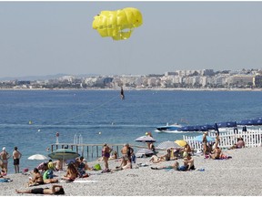 People sunbath in the beach of the Promenade des Anglais in Nice, southern France, Tuesday, July 19, 2016. Joggers, cyclists and sun-seekers are back on Nice's famed Riviera coast, a further sign of normal life returning on the Promenade des Anglais where dozens were killed in last week's Bastille Day truck attack.
