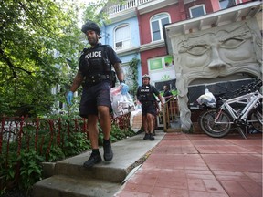 Toronto Police officers carry evidence bags out of the Cannawide marijuana dispensary in Toronto during one of the 43 raids carried out by police in the city on May 26, 2016.