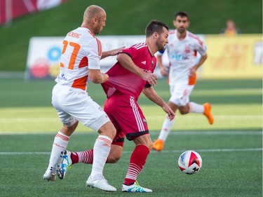 Railhawks player Simon Mensing, left, holds up Thomas Stewart in the first half.