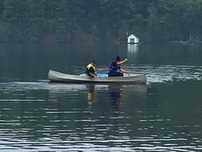 MRC des Collines officers use a commandeered canoe to rescue a man on Meech Lake Monday.
