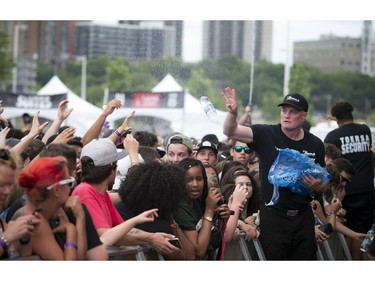 A member of the security staff throws out water to the crowd before Future came on the City Stage.