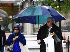 Shoppers walk around in ByWard Market on rainy afternoon on Saturday.