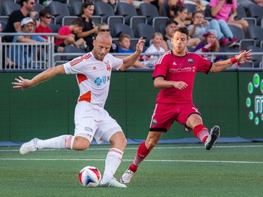 Simon Mensing, left, kicks the ball as Carl Haworth tries to block in the first half.