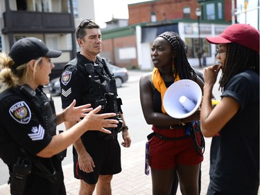 Some of the organizers of March for Justice - In Memory of Abdirahman Abdi chat with police before the march begins. Saturday, July 30, 2016.