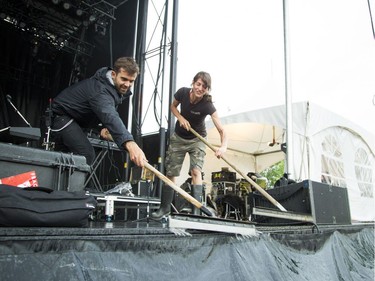 Stage crews squeegee the rain off the Monster stage.