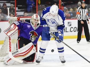 Binghamton Senators goalie Chris Driedger follows the bouncing puck while defending against Syracuse Crunch player Adam Erne in a game at Ottawa in February 2016. Sources say the team will move from Binghamton to Belleville, just down the road from Ottawa.
