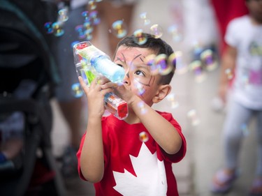 Three-year-old Suliman Abdulaziz shoots a bubble gun on Wellington Street during Canada Day festivities in downtown Ottawa, Friday, July 1, 2016.