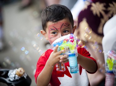 Three-year-old Suliman Abdulaziz shoots a bubble gun on Wellington Street during Canada Day festivities in downtown Ottawa, Friday, July 1, 2016.