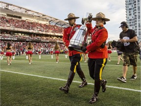 Two RCMP officers carry the Grey Cup on the field at TD Place Arena after the announcement that Ottawa will host the 2017 CFL Grey Cup game at TD Place Arena in Ottawa Sunday, July 31, 2016.