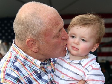 U.S. Ambassador Bruce Heyman gives his grandson a kiss during the U.S. Embassy's 4th of July party held Monday, July 4, 2016, at Lornado, the official residence of the ambassador and his wife.