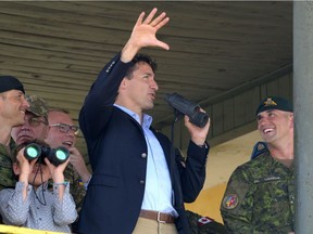 Canadian Prime Minister Justin Trudeau (R) and his son Xavier use binoculars to watch Ukrainian military exercises with Canadian military instructors at the International Peacekeeping and Security Center in Yavoriv, near Lviv, on July 12, 2016. /