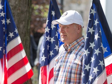 United States Ambassador to Canada Bruce Heyman stands, surrounding by his country's colours.