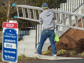 his January 2, 2015 file photo shows a crew member as he moves a ladder around a new homes in Ashburn, Virginia. William Watson writes that labour force numbers are a heartening sign.