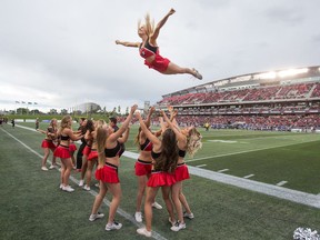 Veteran cheerleader Brittany is flying high as she performs with the stunt team during the first home game of the season. She was a cheerleader with Ottawa University, where she recently graduated in civil engineering, beforee joining the Redblacks cheerleaders.  This is for a feature on the Redblack Cheerleaders.  (WAYNE CUDDINGTON) Assignment - 124013