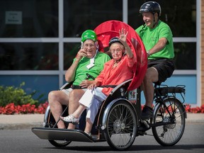 Volunteer Bob Sequin takes Ken Vowles 83, left and Madeleine Sequin 94, for a spin around the Bruyère Continuing Care complex in Ottawa on Wednesday.