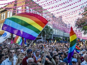 People wave gay pride flags as they take part in a vigil at Parc de lEspoir in Montreal to honour the victims of the June 11/12 shooting attack at the gay nightclub Pulse in Orlando, Florida, on Thursday, June 16, 2016. (Dario Ayala / Montreal Gazette) ORG XMIT: 56475