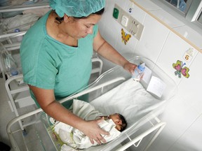 A nurse feeds a newborn afflicted with microcephaly in Honduras. The Canadian government is setting up a national surveillance program to follow pregnant women who have tested positive for the Zika virus, to better track and understand its impact.