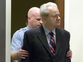 Former Yugoslav president Slobodan Milosevic is led into the courtroom of the UN War Crimes Tribunal in The Hague for his first appearance before the body.