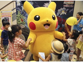 A stuffed toy of Pikachu, a Pokemon character, is surrounded by children during a Pokemon festival in Tokyo.