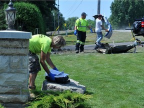 Firefighters and a tow operator clean up the remaining debris of a fiery crash Aug. 4 that left two dead east of Maitland.