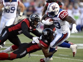 The Ottawa Redblacks' Forrest Hightower, centre, and Nicholas Taylor tackle the Montreal Alouettes' Brandon Rutley during first-half CFL action on Friday, Aug. 19, 2016 at TD Place stadium.