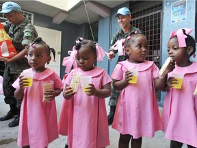 Brazilian UN peacekeepers distribute juice and crackers to students at the Immaculate Conception School February 6, 2013 in Port-au-Prince, Haiti.