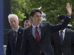 Canadian Prime Minister Justin Trudeau arrives with Foreign Affairs Minister Stephane Dion and Minister of National Defence Minister Harjit Sajjan at the NATO summit in Warsaw, Friday July 8, 2016.