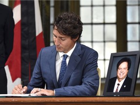 Prime Minister Justin Trudeau signs a book of condolence for Liberal MP Mauril Belanger, who died Tuesday, on Parliament Hill, Wednesday, Aug. 17, 2016 in Ottawa. Belanger, 61, who served as MP for Ottawa-Vanier since 1995, was diagnosed with ALS, also known as Lou Gehrig's disease, in November 2015.