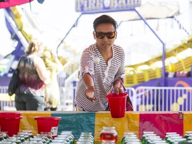 Kristoffer Humilde throws ping pong balls into fish bowls, at the Capital Fair.