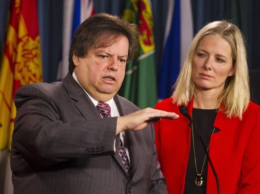 Liberal MP Mauril Belanger, left, speaks while Catherine McKenna, Liberal candidate for Ottawa Centre, right, looks on at a press conference on Parliament Hill to call on the government to reconsider the location of the Memorial to the Victims of Communism Thursday February 26, 2015.