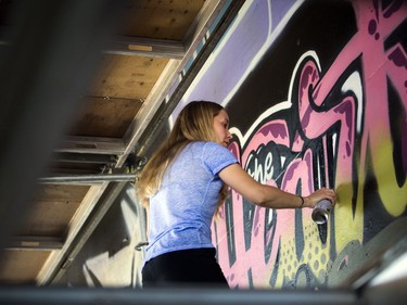 Liz Petrova works on a piece of urban art at the 13th annual House of PainT Festival under the George Dunbar Bridge in Brewer Park on Saturday, Aug. 27, 2016.