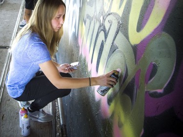 Liz Petrova works on a piece of urban art at the 13th annual House of PainT Festival.