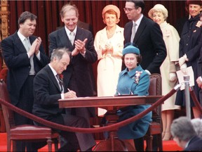 Queen Elizabeth II signs Canada's constitutional proclamation in Ottawa on April 17, 1982 as Prime Minister Pierre Trudeau looks on.