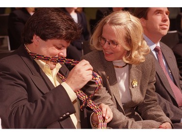 In 1999, Ottawa MP, Mauril Belanger, ties on his new colourful tulip-inspired tie as Patti Giffin gets a chuckle from his antics during the official kickoff for the tulip festival Tuesday at the Rideau Centre.